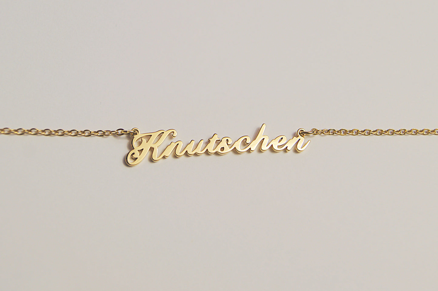 Goldfarbene Kette mit dem Schriftzug Knutschen