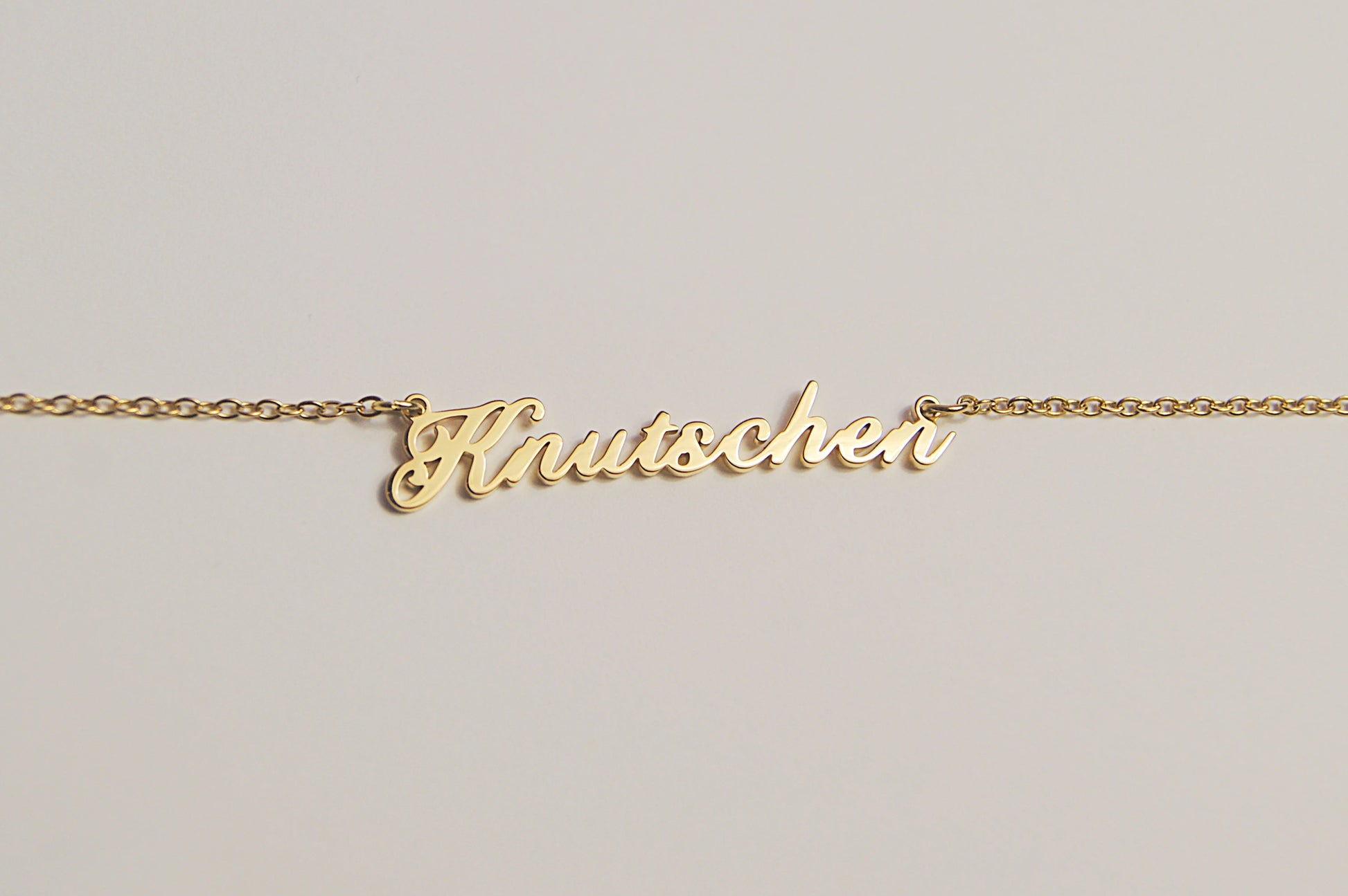 Goldfarbene Kette mit dem Schriftzug Knutschen