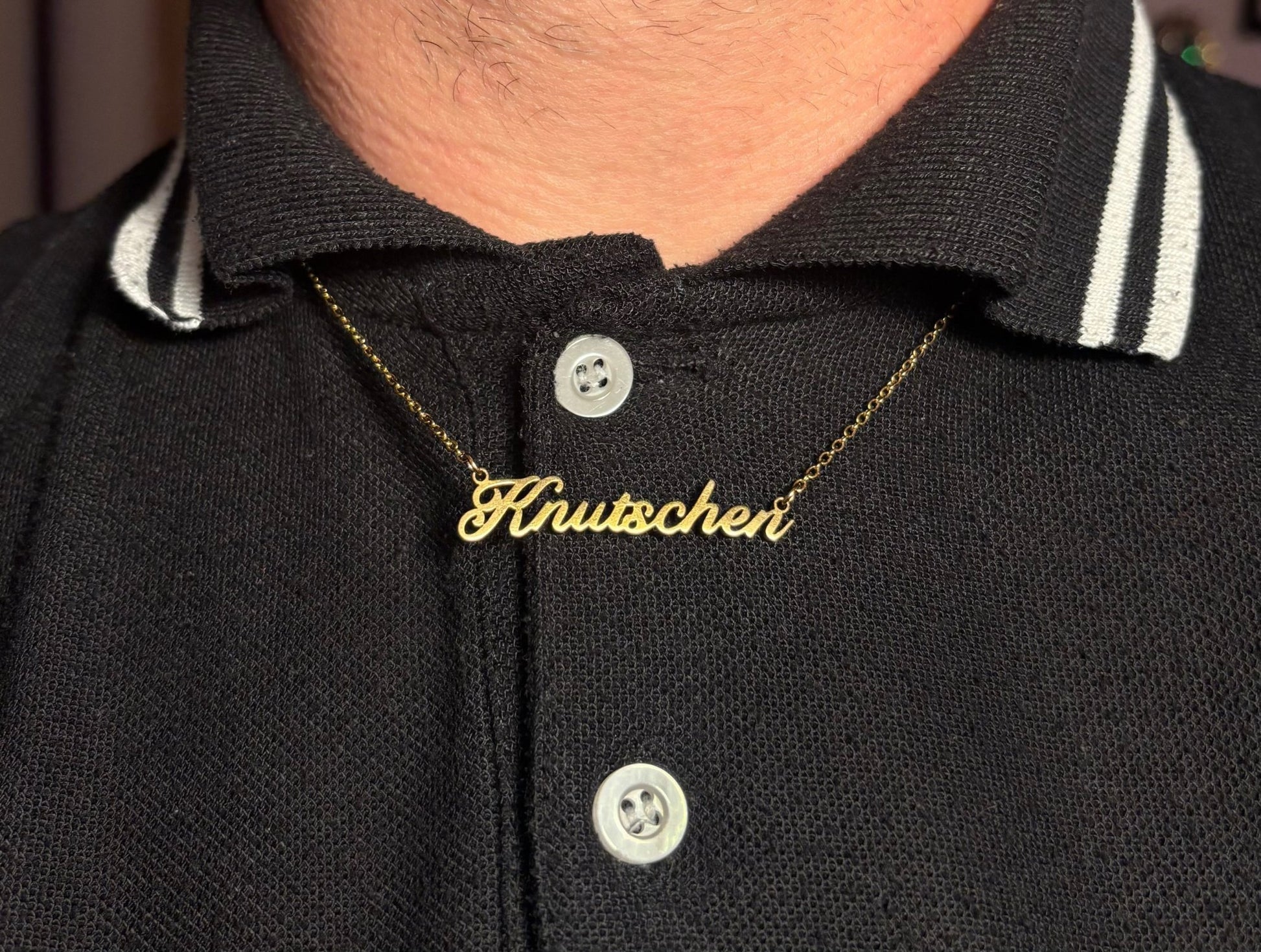 Goldfarbene Knutschen Kette getragen auf schwarzem T-Shirt