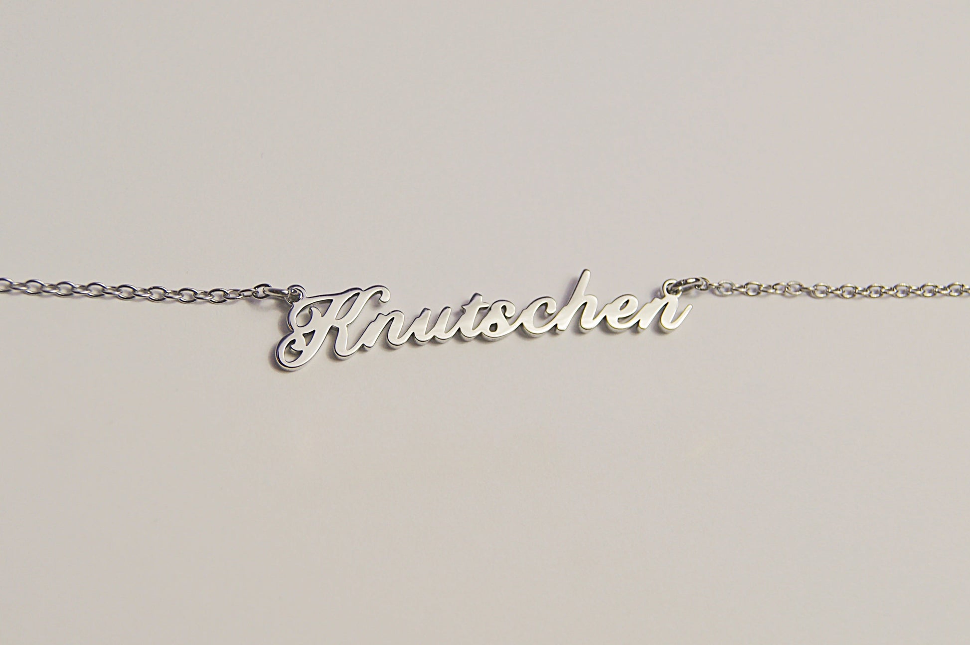 Silberfarbene Kette mit dem Schriftzug Kn